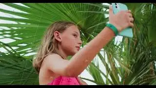 Teen Girl is Making Selfie Under Palm Tree during Her Tropical Vacations.