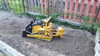 бульдозер на радиоуправлении Bruder выкапывает яму