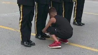 Boy helps Arlington Honor Guard tie his shoe during Fourth of July parade