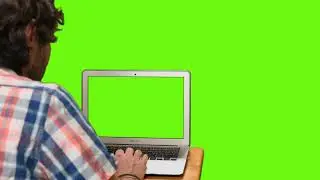 Boy on his computer with green screen on a chroma background