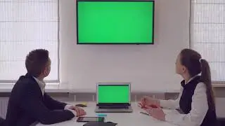 Manager Giving Presentation For Client Showing On Monitor With Green Screen - No Copyright