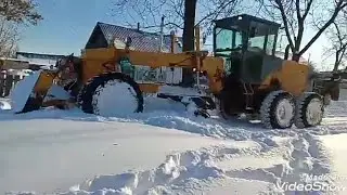 Работа грейдера на расчистке заснеженных улиц.