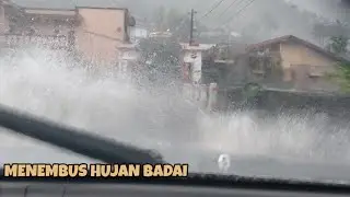 Menembus hujan badai menelusuri jalan di perkampungan saat hujan deras