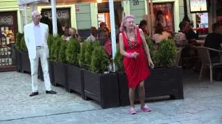 Old and drunk woman dancing in the street