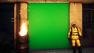 A man in a yellow protective suit stands outside the building against a green screen. Men in