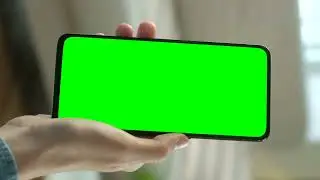 Hand showing a cellphone with a chroma key screen