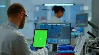 Man doctor holding tablet with green screen