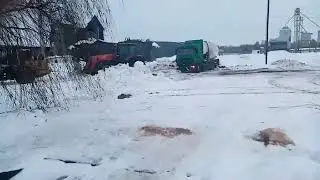 Погрузчик Амкодор и трактор МТЗ 3522 вытягивают из снега застрявший МАЗ
