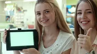 Young women showing a tablet with a green screen || green screen ||no copyright